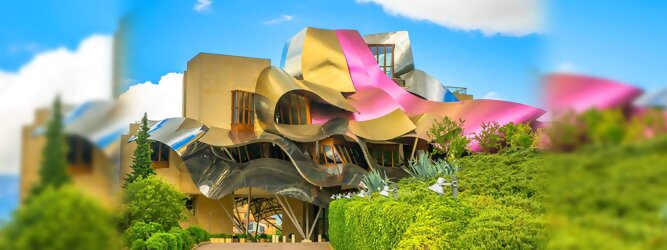 Trip Schweiz Reisetipps - Marqués de Riscal Design Hotel, Bilbao, Elciego, Spanien. Fantastisch galaktisch, unverkennbar ein Werk von Frank O. Gehry. Inmitten idyllischer Weinberge in der Rioja Region des Baskenlandes, bezaubert das schimmernde Bauobjekt mit einer Struktur bunter, edel glänzender verflochtener Metallbänder. Glanz im Baskenland - Es muss etwas ganz Besonderes sein. Emotional, zukunftsweisend, einzigartig. Denn in dieser Region, etwa 133 km südlich von Bilbao, sind Weingüter normalerweise nicht für die Öffentlichkeit zugänglich.